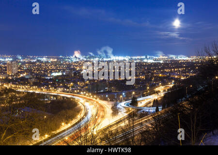 En regardant vers la zone industrielle de Hamilton à partir de l'Escarpement du Niagara, (Hamilton Mountain) de nuit sous la pleine lune. Hamilton, Ontario, Canada. Banque D'Images