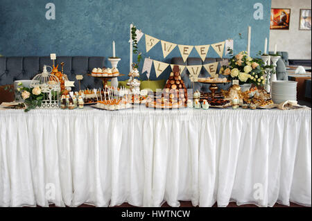 Table de banquet avec des bonbons sur nappe blanche Banque D'Images