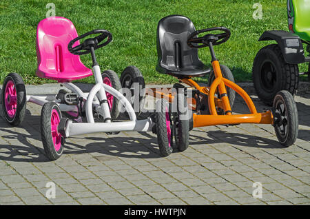 Deux vélos à quatre roues sur la chaussée au parc d'attractions Banque D'Images