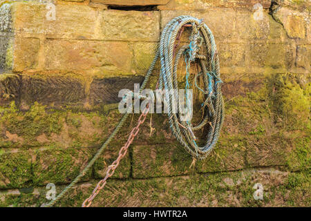 Staithes, Angleterre - 1 mars : la corde de bateau de pêche contre vert texturé mur moussu. arrière-plan à staithes, North Yorkshire, Angleterre. le 1er mars 2017. Banque D'Images