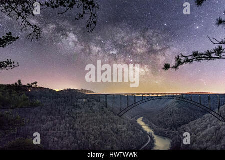 Vue du dessus de Soleil Appuyer sur la fin de l'hiver un matin, le cœur de la Voie lactée se lève comme une bannière au sud sur l'emblématique pont en acier. Banque D'Images