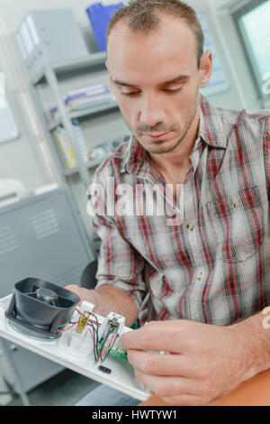 Man looking at ventilateur pour appareil électrique Banque D'Images