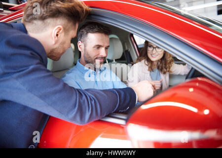 Conseiller vendeur de voiture couple avec vehicale Banque D'Images