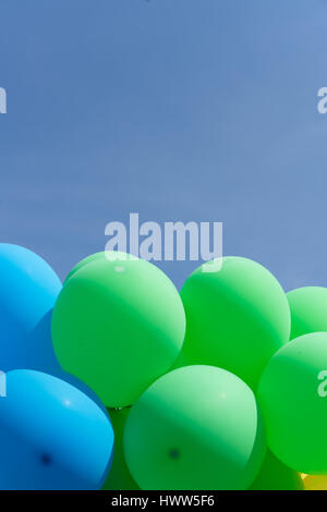 Ballons Multi couleur en un tas flottant dans le ciel Banque D'Images