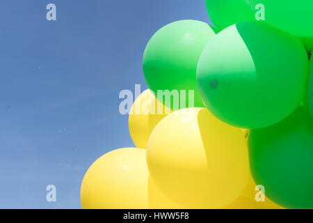 Ballons Multi couleur en un tas flottant dans le ciel Banque D'Images