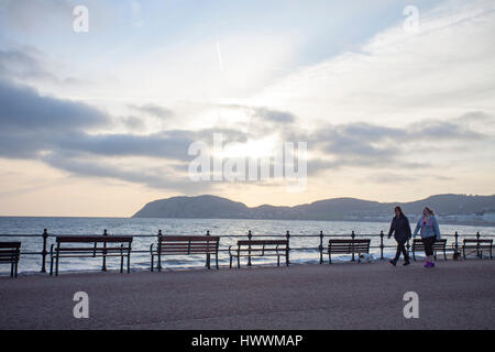 Les personnes prenant un matin tôt à pied le long de la promenade de la célèbre station balnéaire de Llandudno dans le Nord du Pays de Galles Banque D'Images