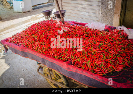 Red Chili Peppers ou empilés sur le chariot en vente soukh de Medina, FES, Maroc. Banque D'Images