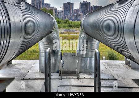 Saint-pétersbourg, Russie - 9 juillet 2015 : Plein air le gazoduc principal de l'eau chaude et le chauffage de bâtiments d'habitation dans une zone urbaine, traversée de pont. Banque D'Images