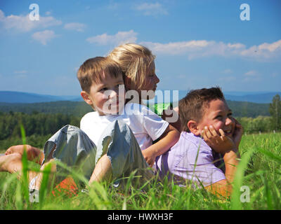 Trois amis heureux jouer à summer meadow Banque D'Images