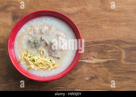 Congee, porridge de riz, riz gruel, soupe de riz sur fond de bois, vue du dessus. Banque D'Images