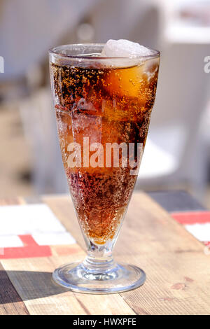 Un verre de Coca Cola o une table en attente d'être bu une chaude journée ensoleillée Banque D'Images