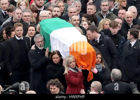 Son groupe est Michelle O'Neill (avant gauche), Mary Lou McDonald (milieu gauche) et Gerry Adams, transporter le cercueil de l'Irlande du Nord l'ancien vice-premier ministre et ex-commandant de l'IRA Martin McGuinness bas Westland Street dans le Bogside à venir de ses funérailles à l'église de saint Colomba Tour Long, à Londonderry. Banque D'Images