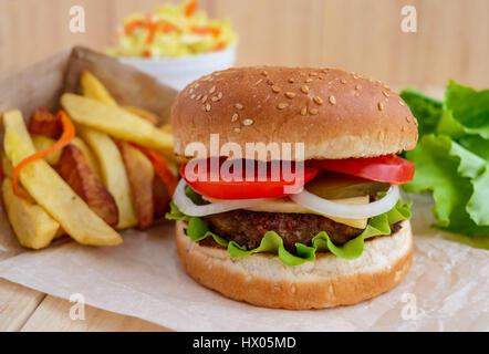 Accueil sandwich hamburger buns doux, fromage, tomates et salade de chou. Burger Juteux. frites. restauration rapide. Banque D'Images