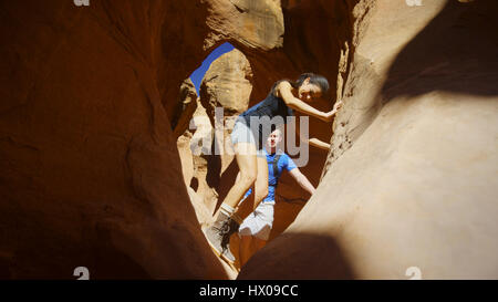 Low angle view point sélective de petit ami et petite amie l'exploration de caverne dans des formations rocheuses pittoresques Banque D'Images