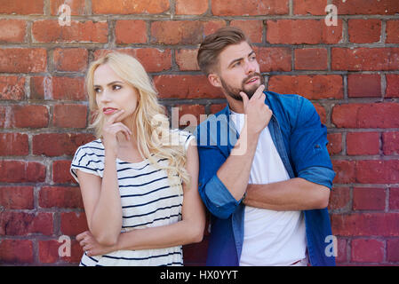 Couple sérieux et le mur de brique Banque D'Images