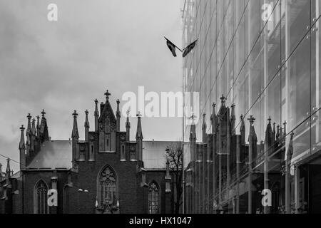 Protestante luthérienne Saint Gertrude avec réflexion au Canada bâtiment Ambassade à Riga, Lettonie, ciel nuageux pluvieux, noir et blanc. Banque D'Images