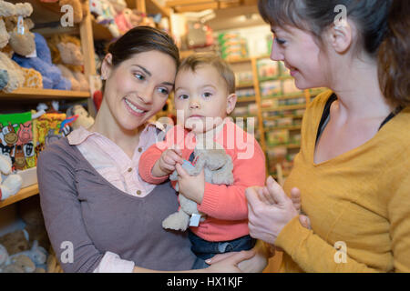 Mère et fille avec des forfaits en magasin de jouets Banque D'Images