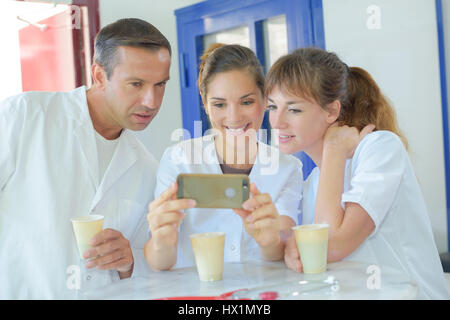 Le personnel médical sur pause, looking at cell phone Banque D'Images
