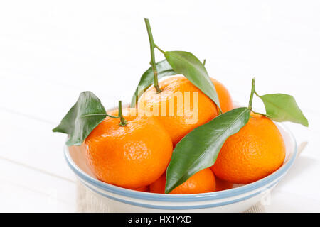 Bol de tangerines fraîches avec des feuilles - close up Banque D'Images