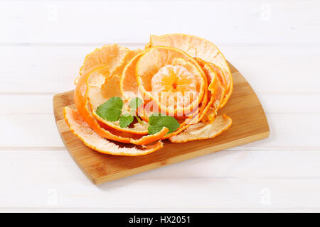 Peeled tangerine disposés en peels sur planche à découper en bois Banque D'Images