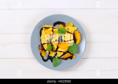 Assiette de crêpes avec des oranges et chocolat topping sur fond blanc Banque D'Images