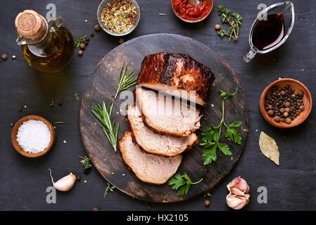 Tranches de viande de porc grillées sur barbecue planche à découper en bois sur fond sombre, vue du dessus Banque D'Images