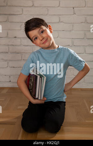 Portrait of a cute kid holding books pour l'étude Banque D'Images