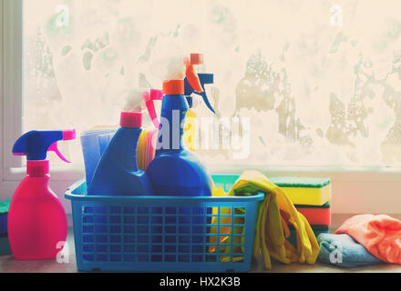 Le nettoyage de printemps - récipient avec des gants de caoutchouc et de sprays, on windowsill, tons rétro Banque D'Images