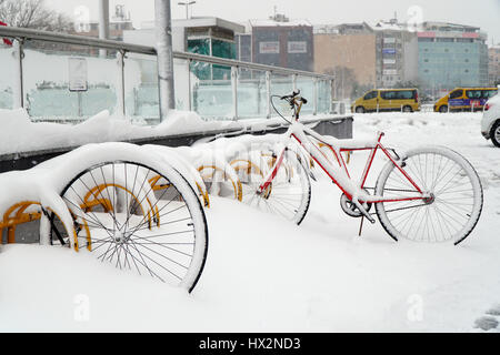 Stock Photo - Istanbul, Turquie - 7 janvier 2017 : le vol de vélo sur la neige à Kadikoy Istanbul avec certains bâtiments et véhicules. Banque D'Images