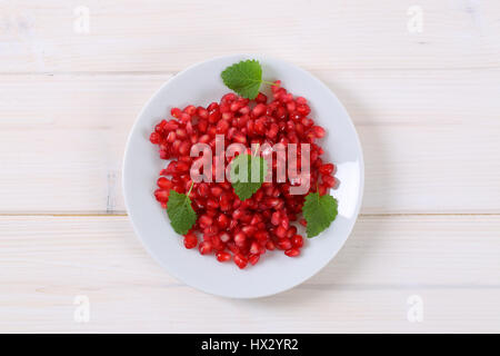Assiette de graines de grenade sur fond blanc Banque D'Images