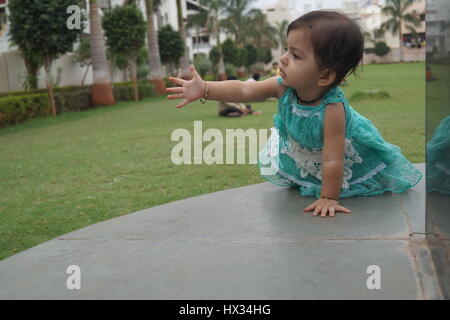 Mignon bébé indien demande à jouer au jardin local quelque part à l'Inde Banque D'Images