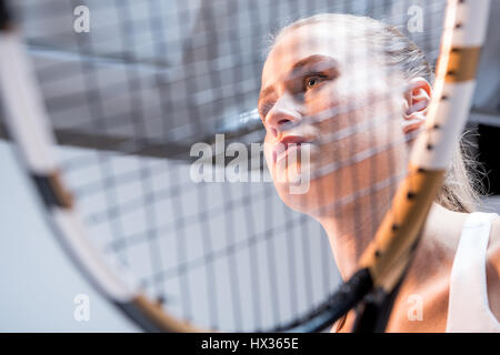 Attractive young woman holding tennis racquet et à l'écart Banque D'Images