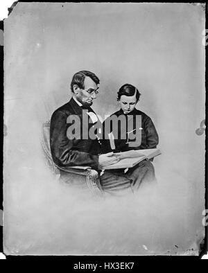 Portrait de l'ex-président des États-Unis Abraham Lincoln assis et lire un livre à son plus jeune fils, Tad Lincoln, 1863. L'image de courtoisie des Archives nationales. Banque D'Images