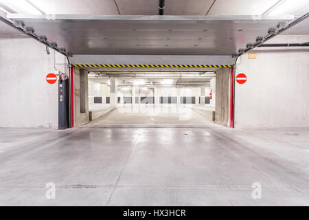 Parc souterrain d'un centre commercial avec des colonnes et des conduits de ventilation Banque D'Images