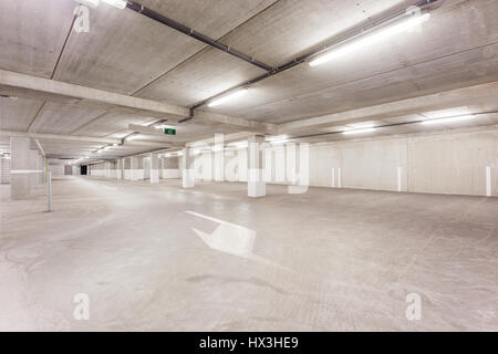 Parc souterrain d'un centre commercial avec des colonnes et des conduits de ventilation Banque D'Images