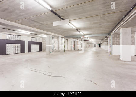 Parc souterrain d'un centre commercial avec des colonnes et des conduits de ventilation Banque D'Images