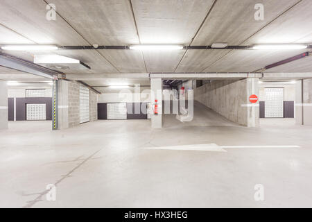 Parc souterrain d'un centre commercial avec des colonnes et des conduits de ventilation Banque D'Images