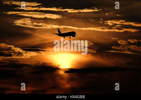 Düsseldorf, Allemagne. Mar 23, 2017. Un avion descentes avec le soleil couchant pour l'atterrissage à l'aéroport de Düsseldorf, Allemagne, 23 mars 2017. Photo : Kevin Kurek/dpa/Alamy Live News Banque D'Images