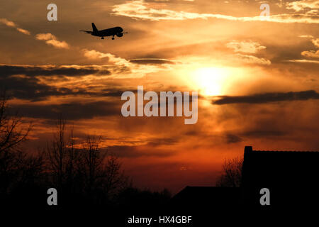 Düsseldorf, Allemagne. Mar 23, 2017. Un avion descentes avec le soleil couchant pour l'atterrissage à l'aéroport de Düsseldorf, Allemagne, 23 mars 2017. Photo : Kevin Kurek/dpa/Alamy Live News Banque D'Images