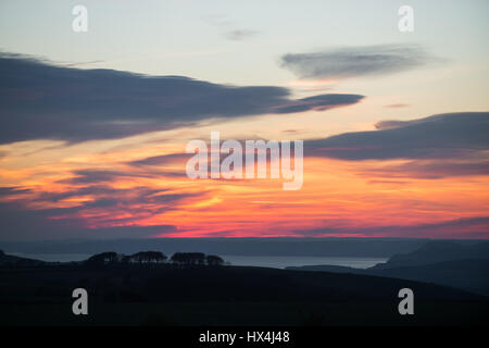 Monument à Hardy, Dorset, UK. 25 mars 2017. Un rouge ardent coucher de soleil sur la baie de l'ouest vers l'ouest du Dorset et de Lyme Regis après une claire et chaude journée ensoleillée. © Dan Tucker/Alamy Live News Banque D'Images