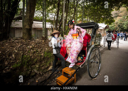 Un pousse-pousse tiré par un homme dans l'uniforme de travail traditionnelles et d'une passagère en kimono, le costume traditionnel japonais, Kyoto, Japon Banque D'Images