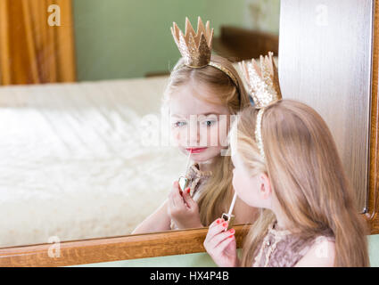 La princesse petite fille peinture makeup sur le miroir Banque D'Images