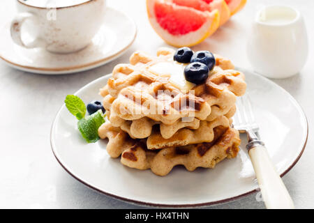 Gaufres savoureuses avec du miel et bleuets servis avec ofcoffee pamplemousse frais et tasse avec de la crème. Vue rapprochée. Table de petit-déjeuner, matinée shot Banque D'Images