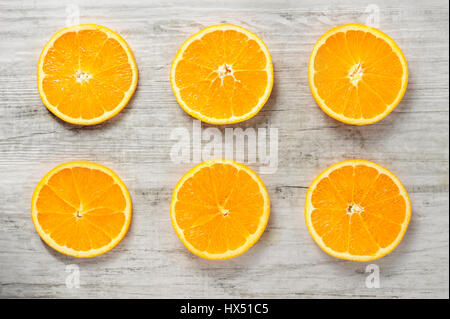 Six tranches d'oranges fraîches sur fond de bois blanc, vue du dessus Banque D'Images