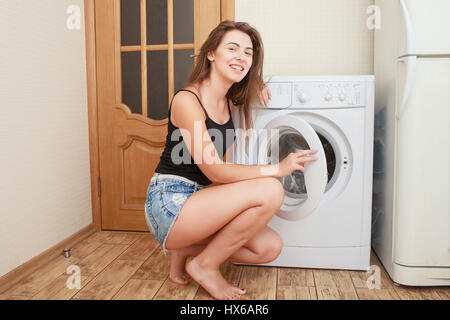 Travaux ménagers : young woman doing laundry, peu profonde, dans les tons de couleur libre Banque D'Images