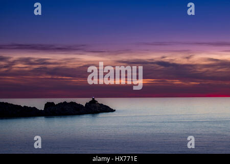 Phare dans le coucher du soleil sur l'île de Grebeni, Dubrovnik, Croatie, voir à partir de la péninsule de Lapad Banque D'Images