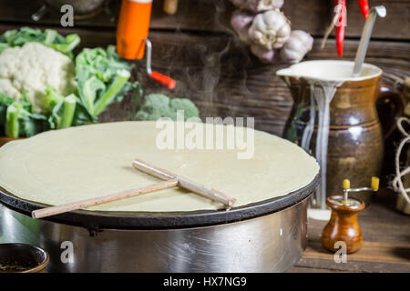 La cuisson des crêpes faites maison dans la campagne sur la vieille table en bois Banque D'Images