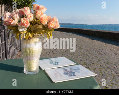 Un vase de roses sur une table de restaurant sur le lac de Bracciano, près de Rome, Italie Banque D'Images