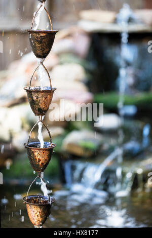 Tasses unique de cuivre utilisé comme un jardin fontaine d'eau. Banque D'Images