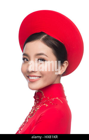 Charmante épouse vietnamienne en ao Dai rouge robe traditionnelle avec chapeau. Banque D'Images